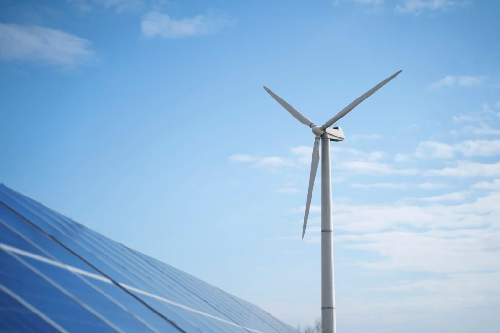 Image of solar panels and wind turbine in the blue sky background